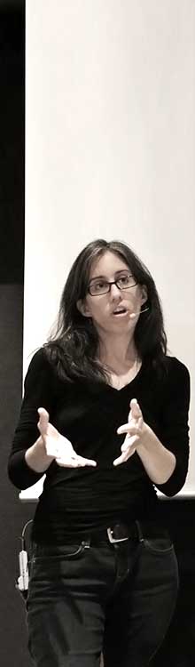 Photo portrait en plan buste de Jen Simmons. Elle est en extérieur, la photo est ensoleillée.